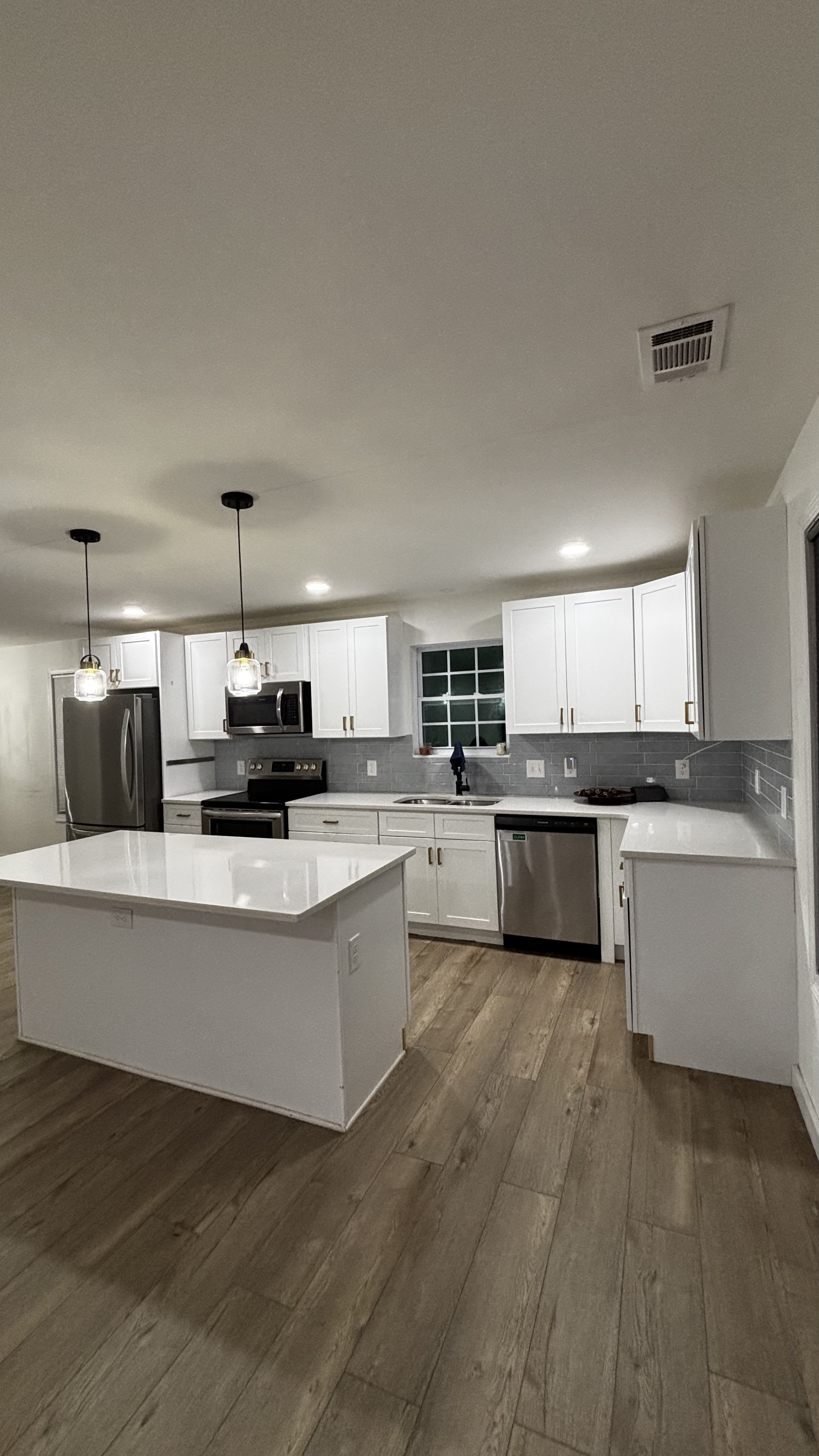 Bright kitchen renovation with white shaker cabinets and quartz countertops